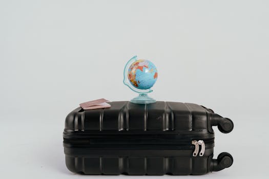A globe placed on a black suitcase symbolizing global travel and adventure.
